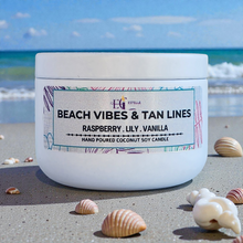 Load image into Gallery viewer, Candle jar labeled 'Beach Vibes &amp; Tan Lines' on a sandy beach with ocean view