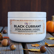 Load image into Gallery viewer, White candle jar with 'Black Currant' label on a wooden surface with pumpkins and acorns.
Saffron, blackberry patchouli 