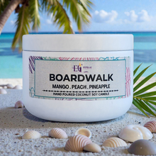 Load image into Gallery viewer, Candle labeled 'Boardwalk' on a beach with palm leaves and ocean in the background