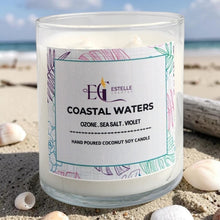 Load image into Gallery viewer, Candle labeled 'Coastal Waters' on a beach with ocean view. Ozone, sea salt, violet 