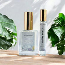 Load image into Gallery viewer, This image features two elegantly designed bottles of Eau De Parfum, with gold caps. 
