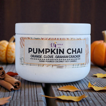 Load image into Gallery viewer, Candle jar labeled 'Pumpkin Chai' with pumpkins and cinnamon sticks on a wooden surface.