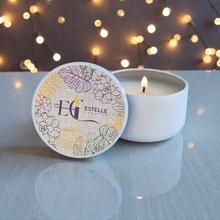 Load image into Gallery viewer, Mini Candle with decorative lid featuring floral design and 'Estelle Creates set against a softly blurred background with lights.
